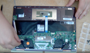 Someone taking apart the back of a computer as part of a computer tune-up.