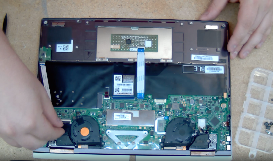 Someone taking apart the back of a computer as part of a computer tune-up.