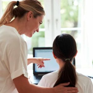 A mother teaching computer safety for kids to her daughter.