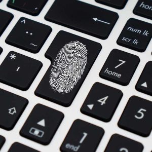 A computer keyboard with a fingerprint on it to represent "computer security"